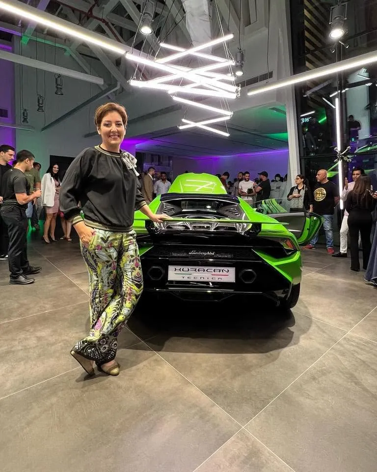 Mehrnoosh standing beside the rear of a green Lamborghini Huracán Tecnica at a crowded launch event